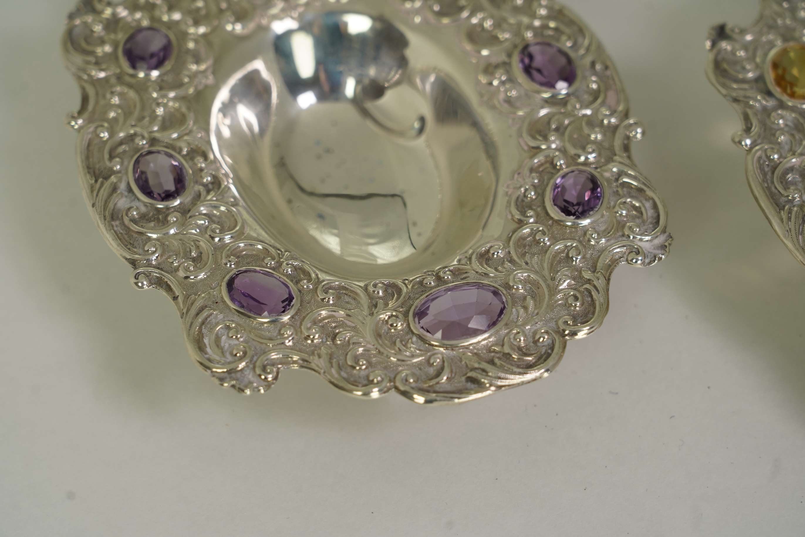 Two unusual late Victorian repousse silver dishes, by Daniel & John Welby, one border inset with eight oval cut amethysts, the other with eight oval cut citrines
